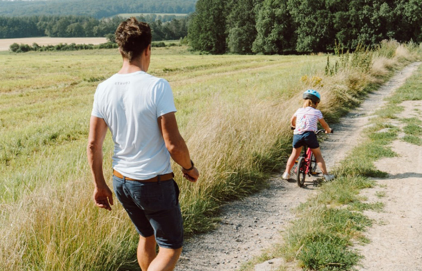 Kind mit Fahrrad in Siegerpose auf Strohballen